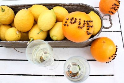 High angle view of citrus fruits in container by drinks on table