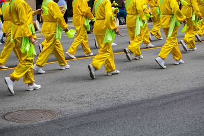 Low section of people in parade walking on street