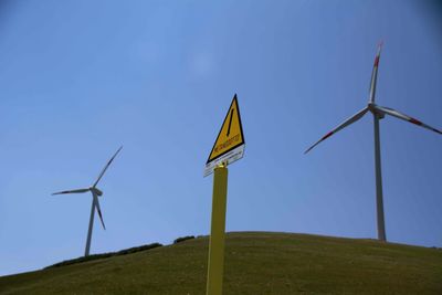 Low angle view of wind turbine on field