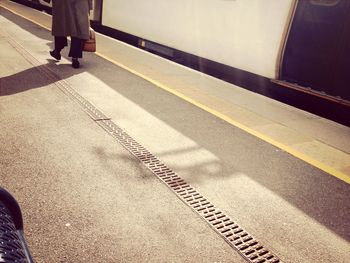 Low section of man with shadow on tiled floor