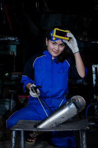Portrait of young woman standing in factory