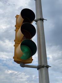 Low angle view of road signal against sky 