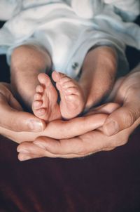 Cropped hand of father holding baby in hand