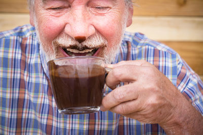 Close-up of senior man drinking coffee at cafe