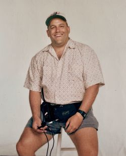 Portrait of a smiling young man standing against wall