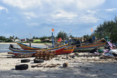 Boats moored on beach against sky