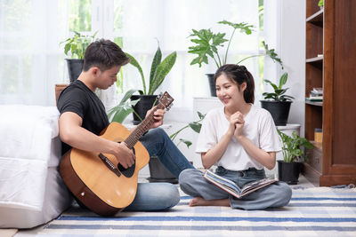 Young couple playing guitar