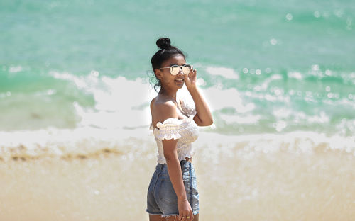 Side view of woman standing at beach