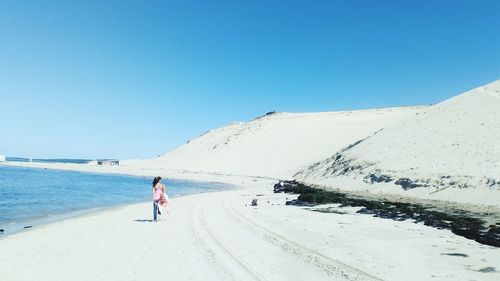 Man riding motorcycle on land against clear blue sky