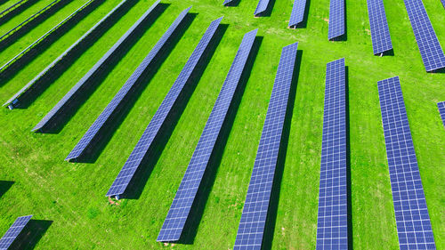 Solar panels in green field, aerial view