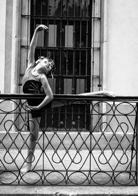 Side view of woman sitting on railing