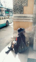 Woman sitting in front of building