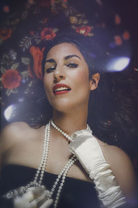 Portrait of woman wearing pearl necklace at night