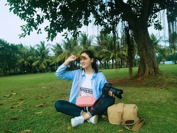 Young woman sitting on field at park