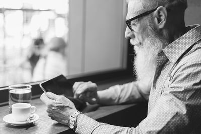 Senior hipster using digital tablet at cafe