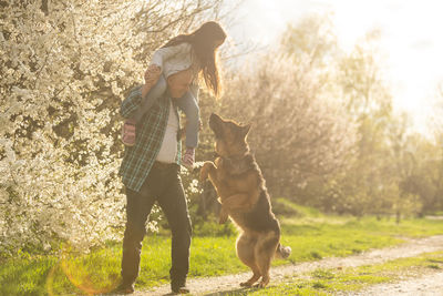 Side view of woman with dog on field