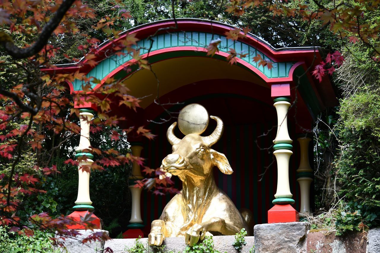 STATUE AGAINST TREES AND BUILDINGS