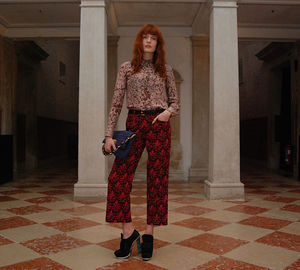 Portrait of woman standing against tiled floor