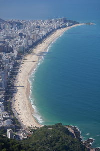 Aerial view of buildings by sea during sunny day