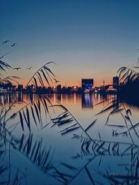 Scenic view of lake against clear sky at sunset