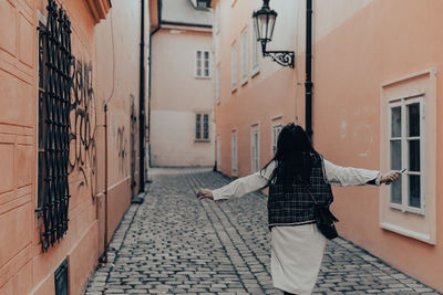 Rear view of woman running on street