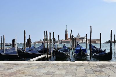 Boats moored in canal against clear sky