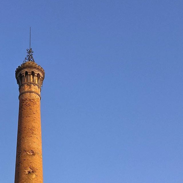 clear sky, copy space, blue, architecture, low angle view, built structure, building exterior, tower, high section, lighthouse, outdoors, tall - high, no people, day, famous place, travel destinations, guidance, sky, nature, travel