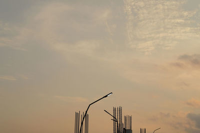 Low angle view of lighting equipment against sky during sunset