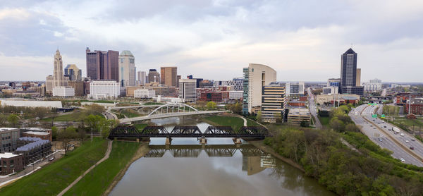 River amidst buildings in city against sky