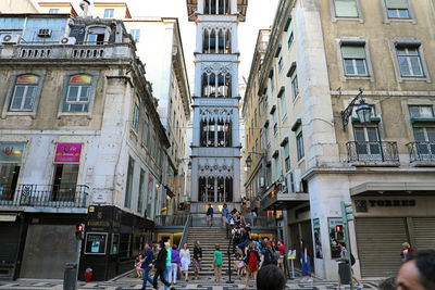 People on street amidst buildings in city