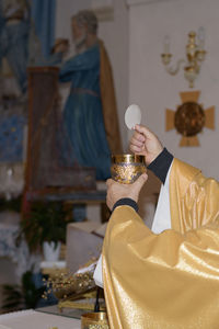 Holy host in the hands of the priest on the altar during the celebration of the mass 