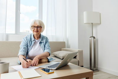 Young woman using laptop at desk in office