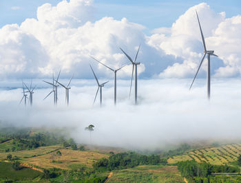 Windmills on field against sky