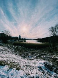 Scenic view of snow covered field against sky