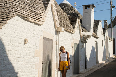 Woman standing by building in town