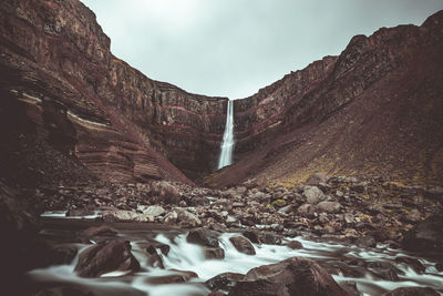 Scenic view of waterfall against sky