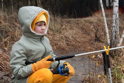 Full length of boy holding camera on land