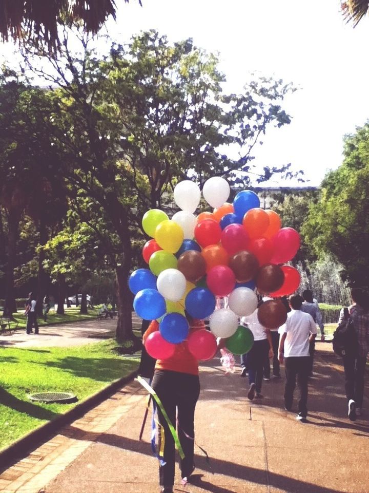 tree, rear view, lifestyles, leisure activity, person, men, walking, fruit, freshness, standing, full length, day, food and drink, balloon, casual clothing, outdoors, multi colored, incidental people