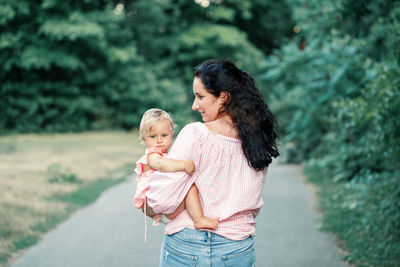 Mother and daughter standing outdoors