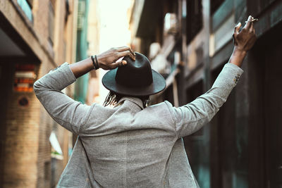 Midsection of woman holding hat in city