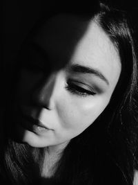 Close-up of woman against black background