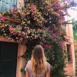 Rear view of woman with flowers against plants