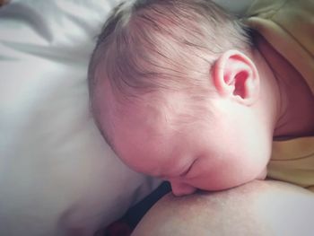 Close-up of baby sleeping in bed