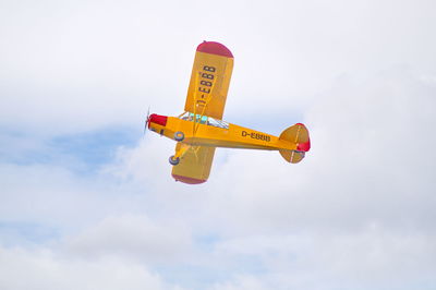 Low angle view of airplane flying against sky