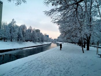 Snow covered landscape by canal