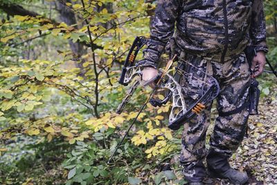 Man standing by tree in forest