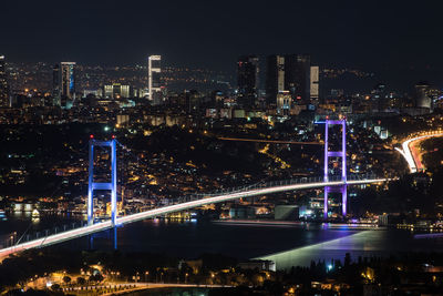 Illuminated bosporus bridge and cityscape at night