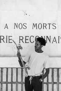 Full length of young man standing against wall