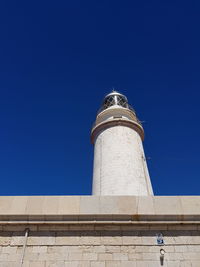 Low angle view of lighthouse against clear blue sky