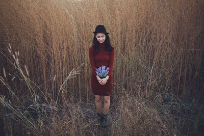 Portrait of young woman standing on field